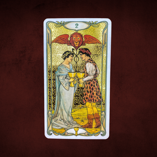 Tarot card with two people holding cups against a lion emblem on a dark brown background